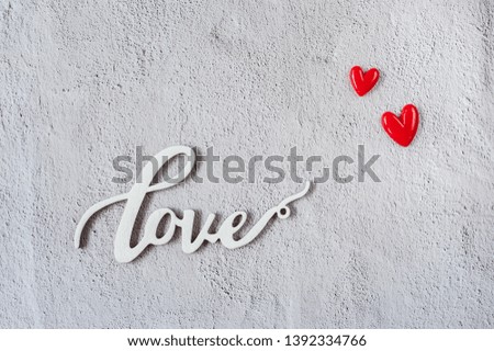Wooden word "love" with red hearts on white background. Love minimal concept. Greeting card. Top view. Flat lay. Copy space.