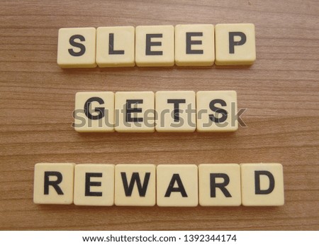 sleep gets reward, word cube on wood background