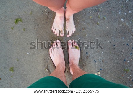 Young couple resting together at beach, top view. Legs on beach in summer time