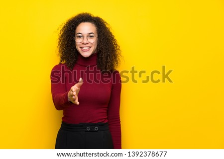 Dominican woman with turtleneck sweater shaking hands for closing a good deal