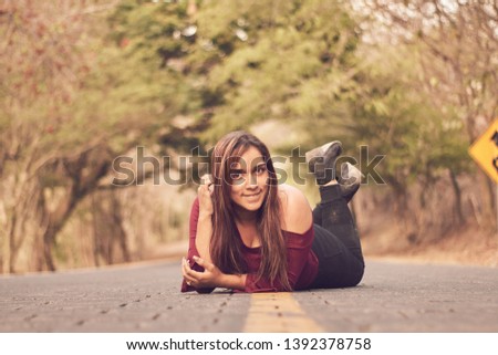 latina girl lying on the road