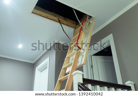 folding attic ladder. Wooden pull down attic folding stairs in small hallway, space saving in home concept Royalty-Free Stock Photo #1392410042