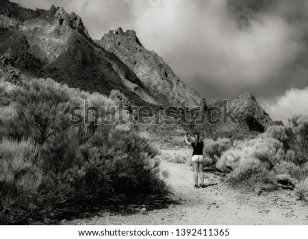 Black and white picture of National Parc El Teide Tenerife with a tourist taking a selfie.