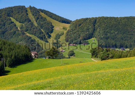 Summer landscape in the mountains. View from above  the tops of the mountains, covered with forest. Mountain village. Slovakia,  Trencin region, near Klacno. Tourist destination, tourism, hiking.