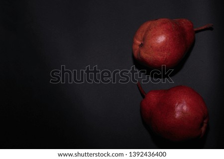 red pears on black background