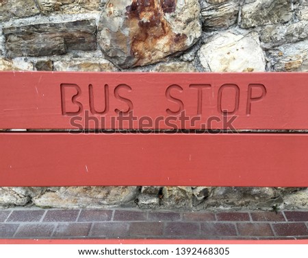 A bench on a sidewalk marked as official bus stop