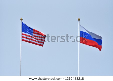 Beautiful and bright flags of the Russian Federation and the United States of America against the sky. Flags of Russia and America as a symbol of cooperation and friendship