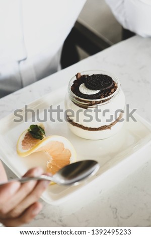 Man holding a delicious milk dessert with sweets in glass jugs