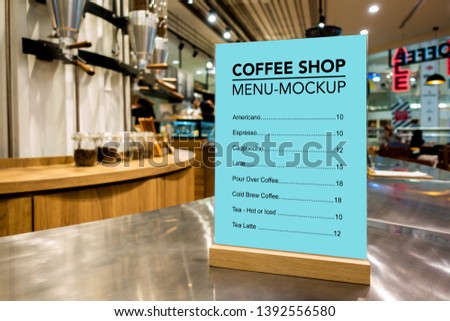 Mock up vertical blank menu in coffee shop with clipping path in acrylic frame placed on counter bar, blue screen empty space for insert list menu and price 