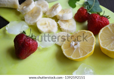 Strawberry and banana smoothie in the jar. Ingredients for making smoothies strawberry banana, frozen berries in a blender on a dark black wooden background.