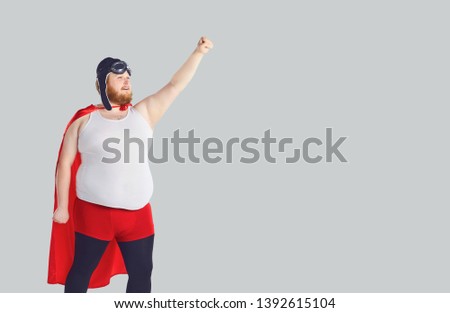 Funny fat man in a superhero costume raised his hand up.
