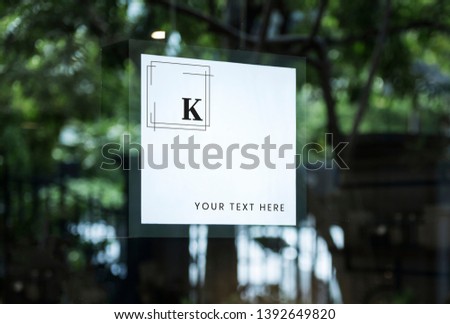 Square white shop sign mockup on a window