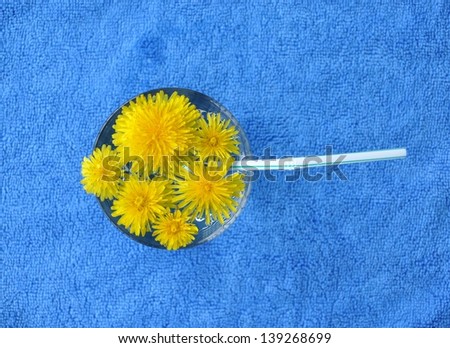 Top view of glass full of water with yellow flowers
