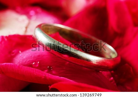 Wedding ring on a red rose petals