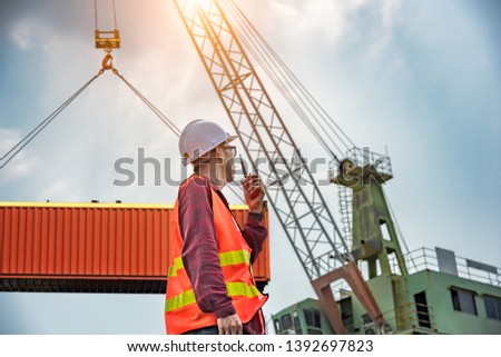 engineering, foreman, supervisor, worker, loading master in work site, control to the teamwork by walkie talkie radio for job done in the same direction, working at risk and high level of insurance Royalty-Free Stock Photo #1392697823