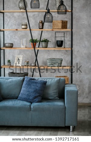 Modern living room interior with blue sofa lamp and green plants on grey wall background,minimal designs.