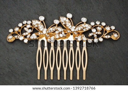 golden bridal hair comb with diamonds isolated  on stone background, stock photography
