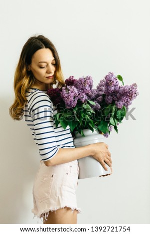 Girl with a bouquet of lilac on a white background