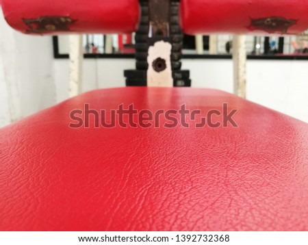 Selective focus on red leatherette of gym seat. 