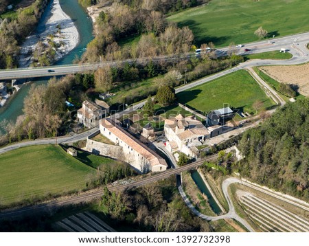 8 April 2019, Saillans, France. Aerial view of a french farm house in the countryside in the Val de Drôme. It is a former monastery built at the shore of river Drome next to a railway track.