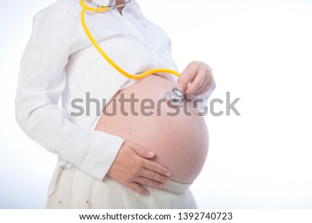 pregnancy, gynecology, medicine, health care and people concept - stethoscope listening to pregnant woman baby heartbeat 