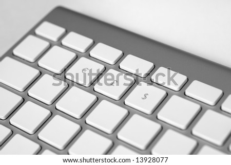Close-up photo of a keyboard with labels of three types of currencies. Shallow depth of field. Focus on the Sterling sign.