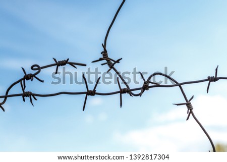 Barbed wire stretched against the cloudy sky