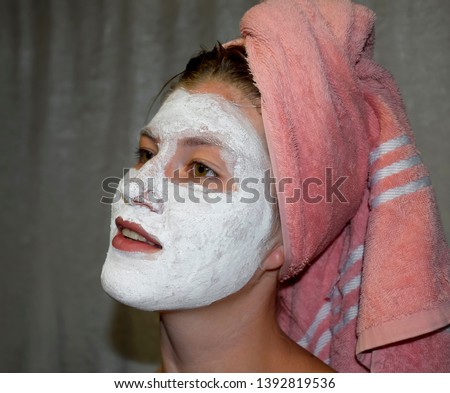 Cosmetic white face mask of toothpaste. Woman in a white cosmetic mask