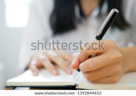 The woman's hand is written using the left hand. Royalty-Free Stock Photo #1392844652
