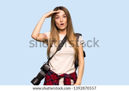 Young photographer woman has just realized something and has intending the solution on isolated blue background
