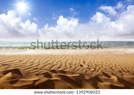 Summer background of sand on beach and sea landscape with sunny sky of blue color. 