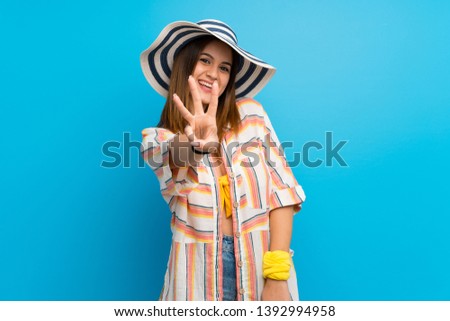 Young woman in bikini in summer holidays happy and counting three with fingers