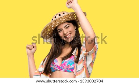 Teenager girl on summer vacation celebrating a victory over isolated yellow background
