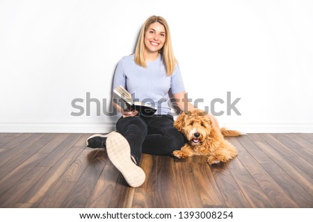 woman with his Golden Labradoodle dog reading book isolated on white background