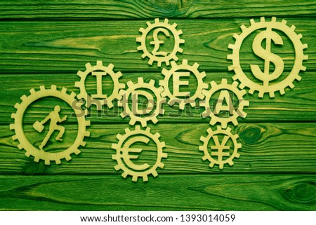 wooden gears, running man, currency signs. idea on a wooden background business ideas. currency operations.