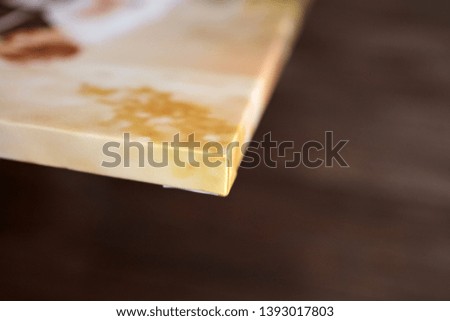 Photo canvas print. Sample of stretched photography with gallery wrapping on a wooden stretcher bar. Lateral side view, closeup. Selective focus