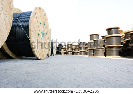 Wooden Coils Of Electric Cable Outdoor. High and low voltage cables in the storage. Royalty-Free Stock Photo #1393042235