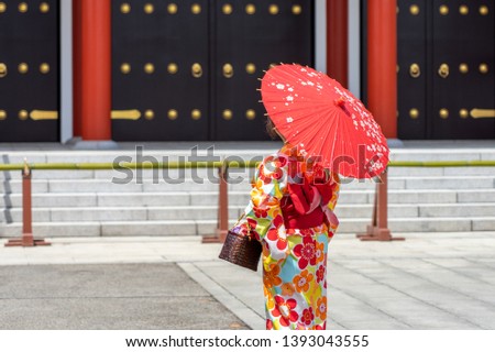 Young girl wearing Japanese kimono standing in front of Sensoji Temple in Tokyo, Japan. Kimono is a Japanese traditional garment. The word "kimono", which actually means a "thing to wear" 