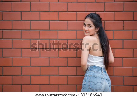 Portrait of beautiful asian chic girl pose for take a picture on brick wall background,Lifestyle of teen thailand people,Modern woman happy concept,Punk rock style