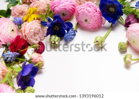 Flowers composition. Frame made of roses, ranunculus and orchids flowers over white background. Flat lay, top view scene.