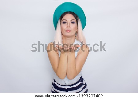 Image of beautiful excited emotional amazing young blonde woman with green hat, posing isolated over white background