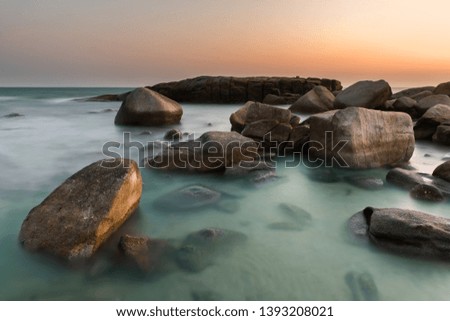 The rock and the sea in the color of sunset time photo with outdoor low and dark lighting seascape.