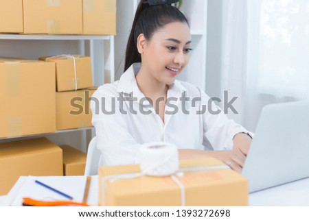 business owner working at home office packaging on background. online shopping SME entrepreneur working Young Women happy after new order from customer.