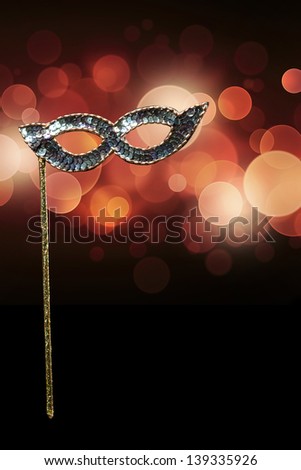 Carnival mask on a black background with red glares