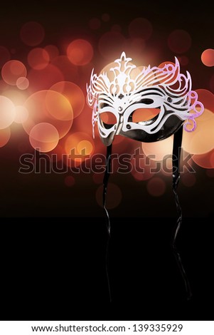 Carnival mask on a black background with red glares