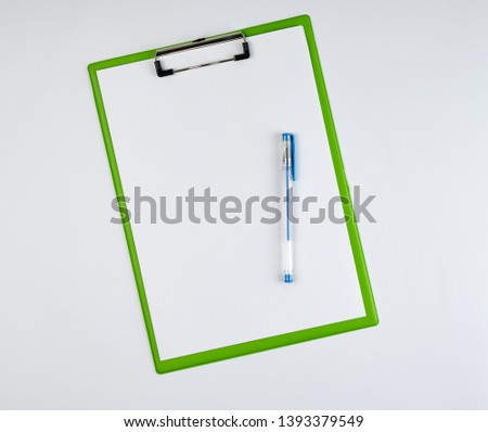 paper clipboard and blue pen on a white background, top view