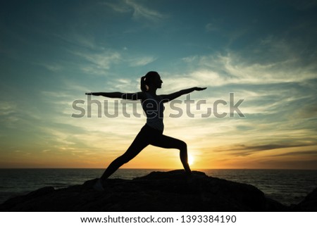 Yoga silhouette meditation girl during beautiful twilight on the sea coast. 