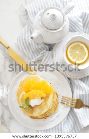 Sliced orange and homemade pancake for breakfast image