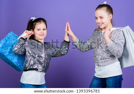 Because image is everything. Girls sisters friends with shopping bags violet background. Shopping and purchase. Black friday. Sale and discount. Shopping day. Children bunch packages. Kids fashion.