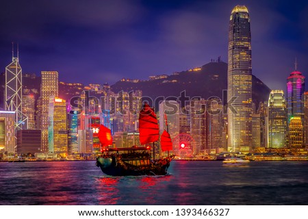 Victoria Harbor Hong Kong night view with tourist sailboat at night. View from across Victoria Harbor Hong Kong. Royalty-Free Stock Photo #1393466327